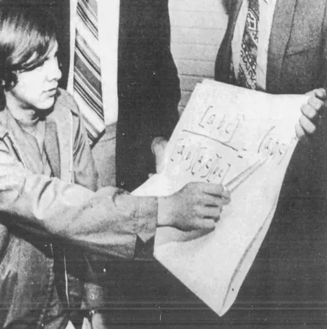 1972 年的哈尔·芬尼，坐在桌前展示数学题